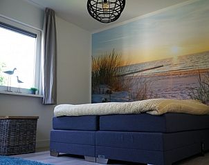 Slaapkamer met stranddecor in Bungalowpark 't Hoogelandt - Texelboogaloo, De Koog, Texel, voor een rustgevende nachtrust.