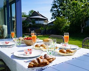 Ontbijttafel op terras van Bungalowpark 't Hoogelandt - Texelboogaloo, De Koog, Texel, met verse broodjes en sap.