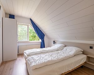 Tweede slaapkamer in Vakantiehuis Kamperfoelie 89 De Koog Texel met comfortabele bedden en uitzicht op de groene omgeving.