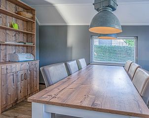 Speisesaal im Ferienhaus Kamperfoelie 87, De Koog, Texel mit groem Holztisch und stimmungsvoller Beleuchtung.