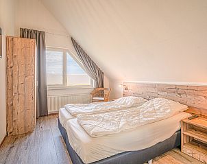 Slaapkamer in Vakantiehuis Kamperfoelie 71, De Koog, Texel, met comfortabel bed en houten details.