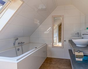 Luxe badkamer in Vakantiehuis Kamperfoelie 71, De Koog, Texel, met ligbad en dubbele wastafel.