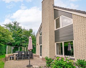 Terras van Vakantiehuis Kamperfoelie 31 in De Koog, Texel met tuinmeubilair en groene omgeving.