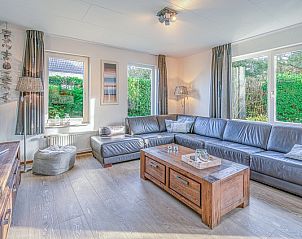 Lichte woonkamer van Vakantiehuis Kamperfoelie 31 in De Koog, Texel met grote ramen en groene uitzichten.