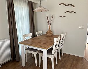 Eethoek in Chalet Bregkoog 213, De Koog, Texel met houten tafel en stijlvolle stoelen.