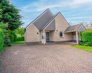 Vooraanzicht van Vakantiehuis Kamperfoelie 65 in De Koog, Texel met ruime oprit en groene omgeving.