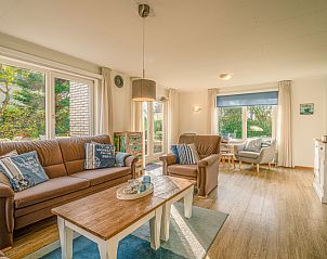 Lichte woonkamer van Vakantiehuis Kamperfoelie 65 in De Koog, Texel met uitzicht op tuin.