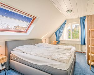 Slaapkamer in Vakantiehuis Kamperfoelie 65, De Koog, Texel met comfortabel bed en dakraam.