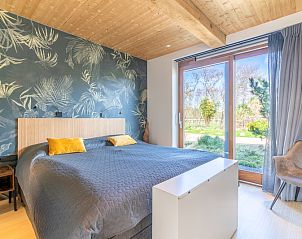 Luxurises Schlafzimmer in der Villa 183 mit Whirlpool in De Koog Texel, mit Blick auf die grne Umgebung.