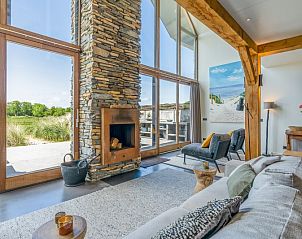 Gezellige woonkamer van Villa 193, De Koog, Texel, met open haard en uitzicht op natuur.