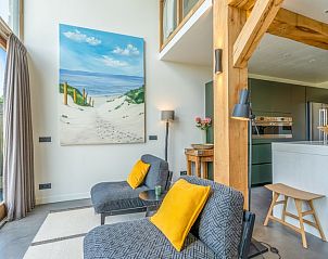 Knusse hoek in Villa 193, De Koog, Texel, met kunst en comfortabele stoelen.