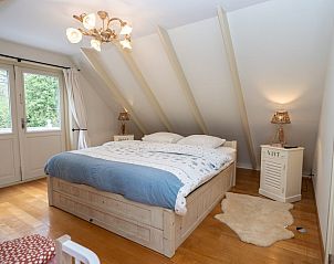 Slaapkamer in Bosrandweg 496, vakantiehuis in De Koog, Texel met comfortabel bed en rustgevende sfeer.