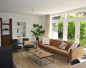 Gezellige woonkamer van Plevierstraat 24 - Tuunwoal in De Koog, Texel, met grote ramen en moderne inrichting.