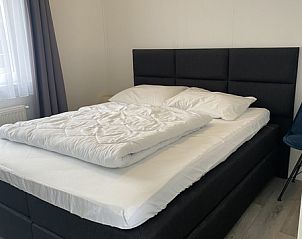 Chalet Bregkoog 94, Texel. Moderne TV-Ecke mit groem Bildschirm und stilvollem Schrank im Wohnzimmer des Ferienhauses.