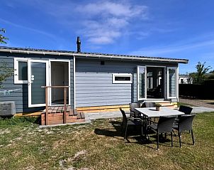 Buitenzijde van Chalet Type 1 in De Koog, Texel met zonnig terras en groene omgeving op de Waddeneilanden.