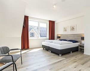 Ruime slaapkamer in Villa 21, De Koog, Texel, met uitzicht op de omgeving en veel daglicht.