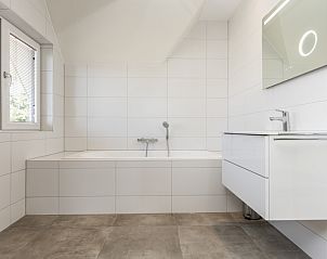 Moderne badkamer in Villa 21, De Koog, Texel, met ligbad en strakke afwerking.