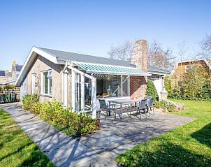 Terras met zonnescherm bij De Schutstal vakantiehuis in De Koog, Texel