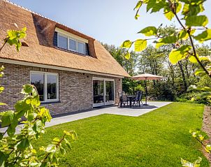 Veranda von Landhuis De Wije Blick, Ferienhaus in De Koog Texel, mit Gartenmbeln und Sonnenschirm.