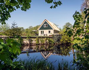 Landhuis De Wije Blick, Ferienhaus in De Koog Texel, das sich in einem ruhigen Teich spiegelt.