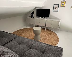 Gemtliches Mansardenzimmer im Ferienhaus De Koerie, De Koog, Texel, mit TV und Dekoration.