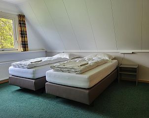 Comfortabele slaapkamer in Agter Mienterglop - Vakantiehuis 5103, Texel, met twee eenpersoonsbedden en uitzicht.