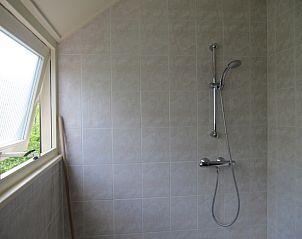 Douche in Agter Mienterglop - Vakantiehuis 5103, De Koog, Texel, met moderne voorzieningen en raam.