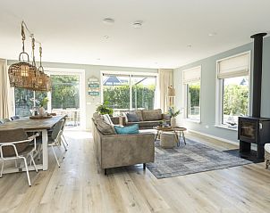 Ruime woonkamer van Villa 15 in De Koog, Texel, met veel lichtinval en een gezellige zithoek op de Waddeneilanden.