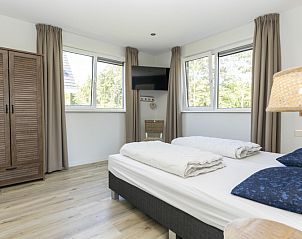 Comfortabele slaapkamer in Villa 15, De Koog, Texel, met uitzicht op de natuur van de Waddeneilanden.