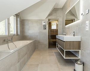 Ruime badkamer met bad in Villa 15, De Koog, Texel, perfect voor ontspanning op de Waddeneilanden.