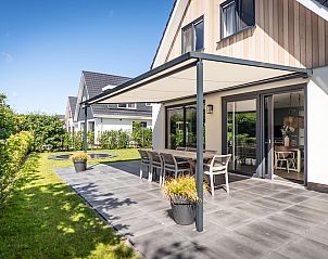 Terras van Villa 15 in De Koog, Texel, met comfortabele zitplaatsen en uitzicht op de groene omgeving van de Waddeneilanden.