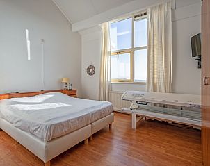 Lichte slaapkamer met groot raam en uitzicht in Resort De Buteriggel - Appartement 9, De Koog, Texel, Waddeneilanden.