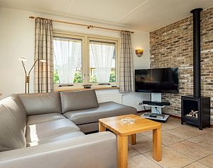 Gezellige woonkamer in Villa met serre, vakantiehuis in De Koog, Texel met comfortabele zithoek en open haard.