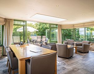 Lichte eetkamer in Villa met serre, vakantiehuis in De Koog, Texel met uitzicht op de tuin, ideaal voor familiediners.