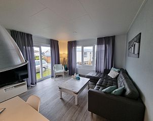 Woonkamer van Chalet Bregkoog 82, De Koog, Texel met comfortabele zithoek en grote ramen.