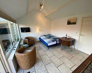 Binnenruimte van Studio Ooster - Brink 28 in De Koog, Texel, met zithoek en slaapgedeelte.