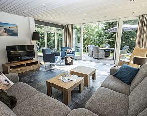 Gezellige woonkamer van Westenwind in De Koog, Texel, met comfortabele banken en uitzicht op de tuin.
