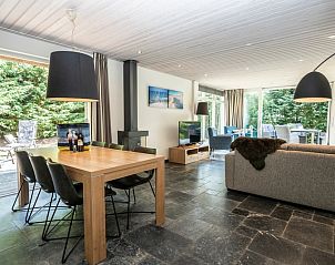 Eethoek en open haard in vakantiehuis Westenwind, De Koog, Texel, met gezellig interieur en toegang tot buiten.