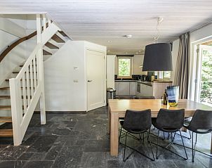 Trap en eetruimte in Westenwind, De Koog, Texel, met toegang tot de bovenverdieping en tuin.