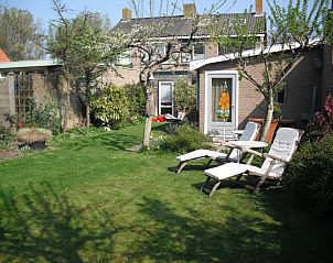 Rustige tuin met ligstoelen bij vakantiehuis Plevierstraat 21 in De Koog, Texel, ideaal voor ontspanning op de Waddeneilanden.