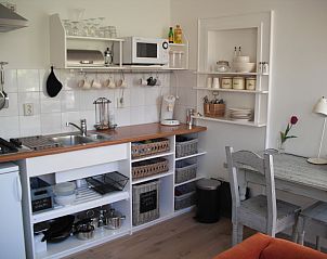 Gezellige keuken in vakantiehuis Plevierstraat 21, De Koog, Texel, met moderne voorzieningen en eetruimte op de Waddeneilanden.
