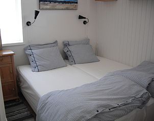 Sfeervolle slaapkamer in vakantiehuis Plevierstraat 21, De Koog, Texel, met comfortabel tweepersoonsbed op de Waddeneilanden.