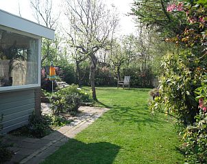 Groene tuin met terras bij Plevierstraat 21, De Koog, Texel, vakantiehuis voor natuurgenieters op de Waddeneilanden.