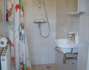 Moderne badkamer in vakantiehuis Plevierstraat 21, De Koog, Texel, met douche en wastafel op de Waddeneilanden.