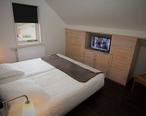 Knusse slaapkamer met TV in Stappeland - De Duinvlinder, vakantiehuis in De Koog, Texel voor ontspannen avonden.