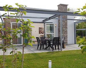 Gezellige veranda van bungalow Schilpbanck 4 in De Koog, Texel, met moderne tuinset en groene omgeving op de Waddeneilanden.