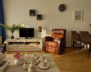 Stijlvolle woonkamer in De Pelikaan Appartementen, De Koog, Texel, met leren fauteuils en eettafel.