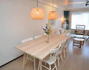 Elegante eetkamer in Appartementen Anna - Zon, De Koog, Texel, met houten tafel en stijlvolle hanglampen.