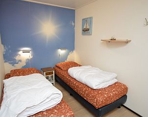 Slaapkamer in Appartementen Anna - Zon, De Koog, Texel, met twee comfortabele bedden en rustgevende wanddecoratie.