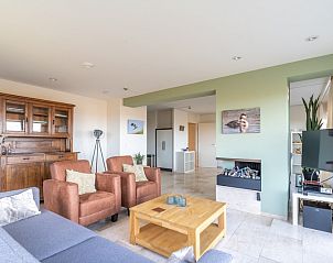 Stijlvolle binnenruimte van Appartement Juliana 066 Zeezicht, De Koog, Texel met open haard en uitzicht op de duinen.